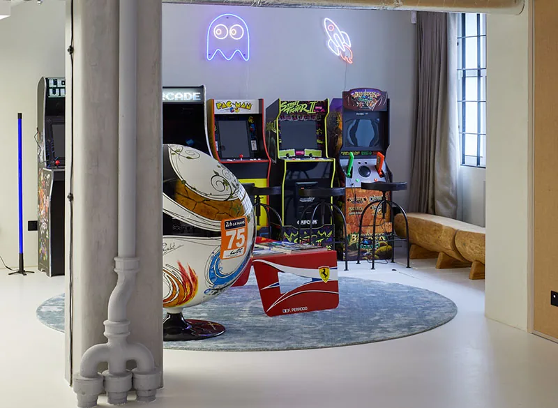 Games area with retro arcade cabinets and neon signage