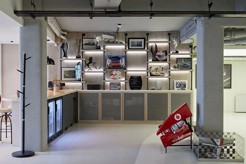 Bespoke joinery and lit display wall beside the bar and kitchenette